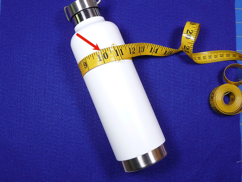 A white water bottle with a measuring tape around it